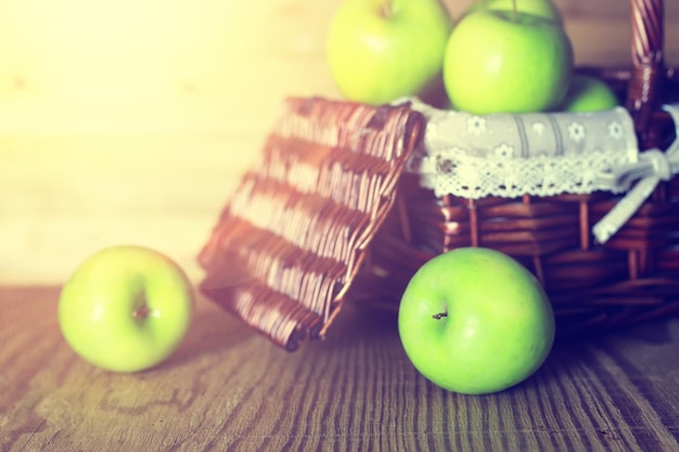 Zonlicht groene appel in een mand houten achtergrond