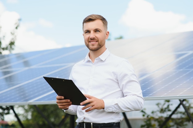 Zonne-energiecentrale Man staande in de buurt van zonnepanelen Hernieuwbare energie