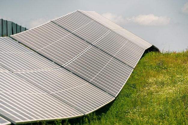 Zonne-fotovoltaïsche elektriciteitscentrale gelegen op de heuvel groen gras en blauwe lucht en witte wolken.