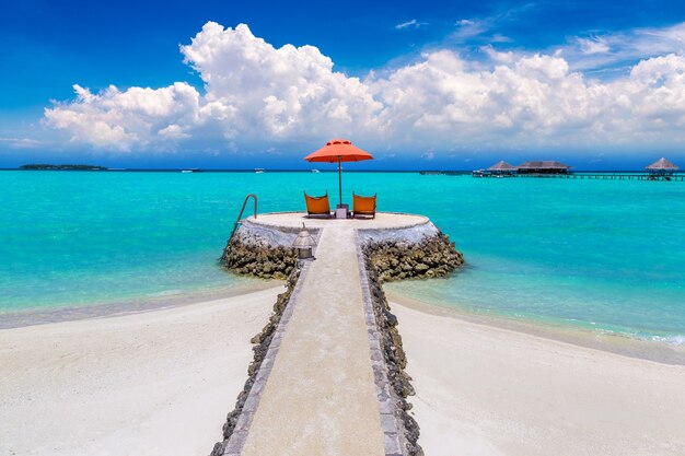 Zonnebank en parasol op tropisch strand in de Malediven