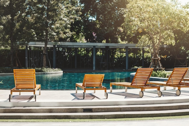 Zonnebank rond blauw zwembadwater niemand voor rustige ontspanningsplek voor zomervakantie vakantie gezellige levensstijl