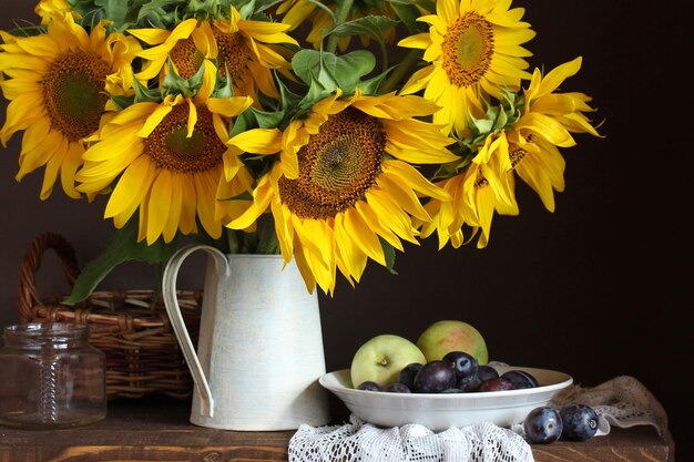 Zonnebloemen, pruimen en appels. zomer stilleven.