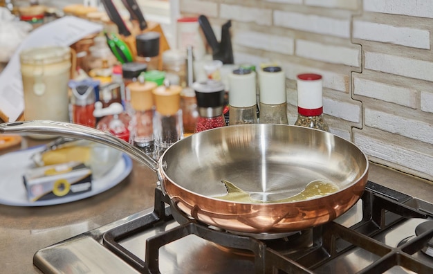 Zonnebloemolie in een koperen pan op een gaskachel