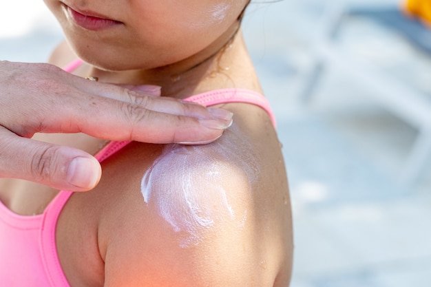 Foto zonnebrandcrème aanbrengen op het gezicht van een klein kind, zon- en ultravioletbescherming