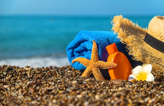 Zonnebrandcrème en bril op het strand. Selectieve aandacht. Reis.