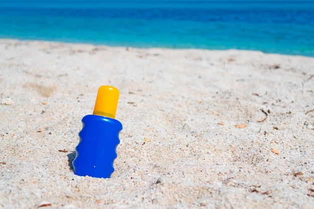 Zonnebrandcrème fles in het zand