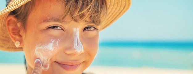 Foto zonnebrandcrème op de huid van een kind.