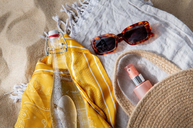 zonnebril zak water fles zonnebrandcrème op het strand