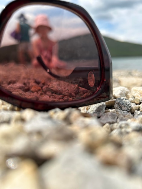 Zonnebrillen op het strand liggen op het zand bij zonsondergang concept van strandvakantie sereniteit