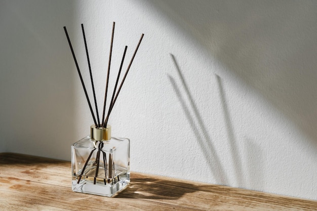 Zonnelichte diffusieflas met riet die schaduw werpt op een witte muur