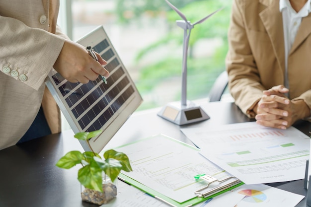 Foto zonnepanelen groene energie mensen uit het bedrijfsleven werken in een groen, milieuvriendelijk kantoor, zakelijke bijeenkomst, creatieve ideeën voor het bedrijfsleven, milieuvriendelijke professionele mensen die duurzame elektriciteit onderwijzen