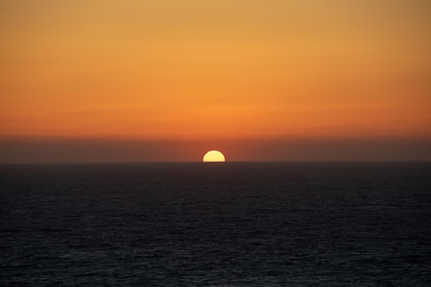 Zonneschijf op zee horizon kleurrijke zonsondergang