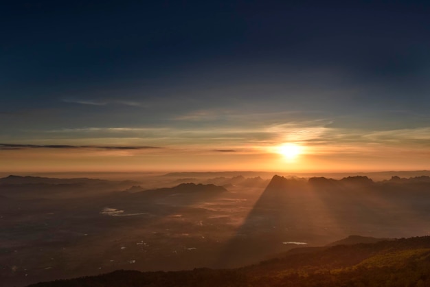 Zonnestraal over bergketensilhouet in een ochtend