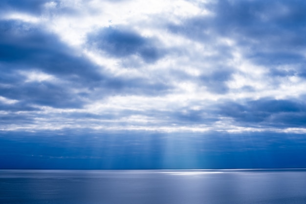 Zonnestralen banen zich een weg door de wolken