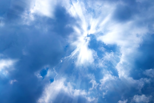 Zonnestralen door de wolken op de blauwe hemel