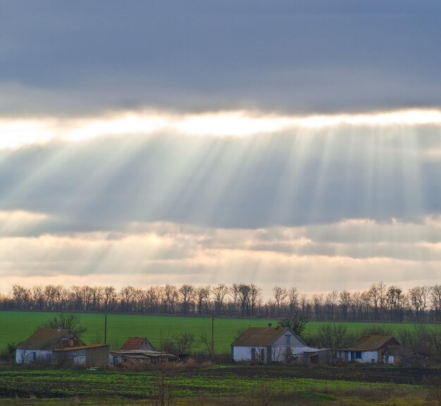 Zonnestralen tegen het dorp.