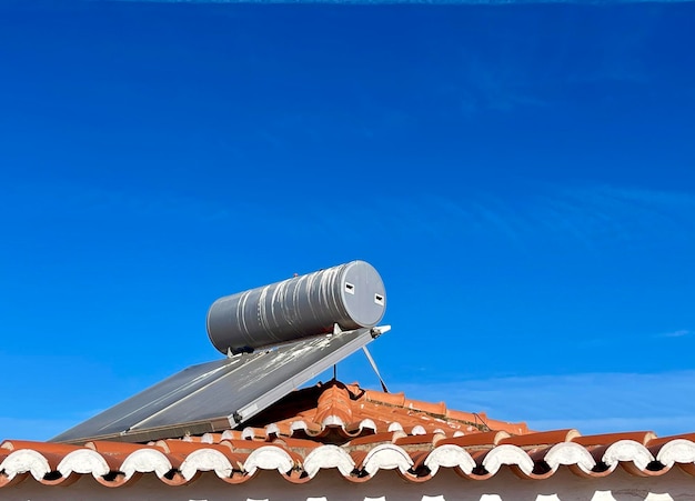 Zonnewaterverwarmer geïnstalleerd op het tegeldak van het huis voor milieuvriendelijk