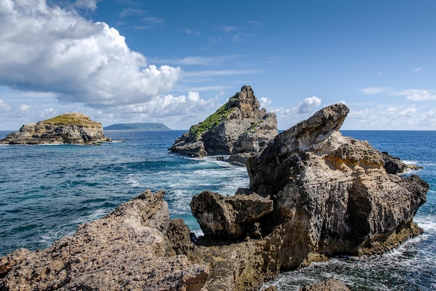 Zonnig uitzicht op de rotsen en het eiland Desirade vanaf Pointe des Châteaux