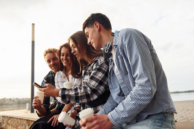 Zonnig weer Koffie drinken Groep jonge vrolijke vrienden die buiten samen plezier hebben