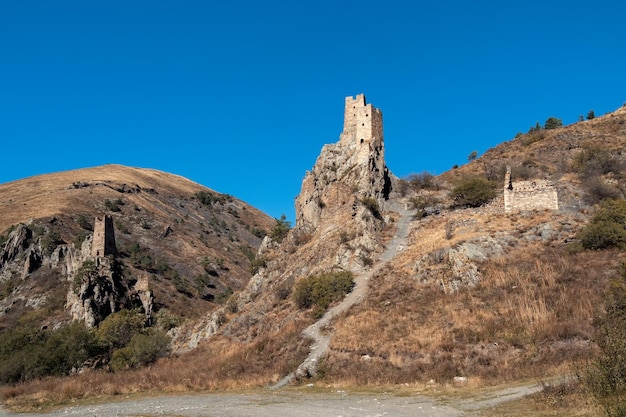 Zonnige middag in de bergen van de Kaukasus Middeleeuws torencomplex Vovnushki, een van de authentieke middeleeuwse torendorpen van het kasteeltype, gelegen aan het uiteinde van de bergketen in Ingoesjetië