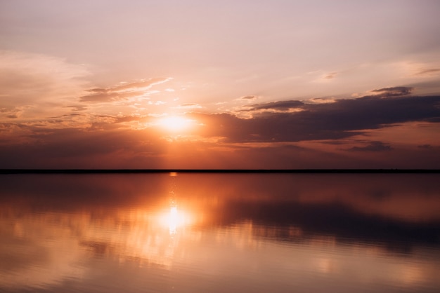 Zonsondergang aan de oever van een roze meerzoutafzetting