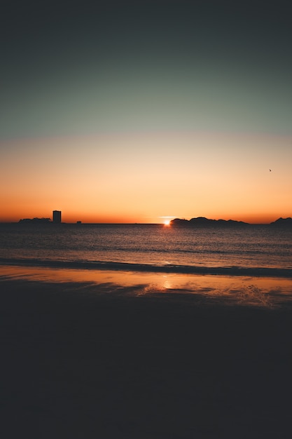 Zonsondergang aan zee met bergsilhouet