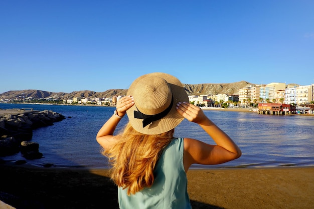 Zonsondergang achteraanzicht van meisje met strohoed in crotone-stad aan de kust van calabrië, italië