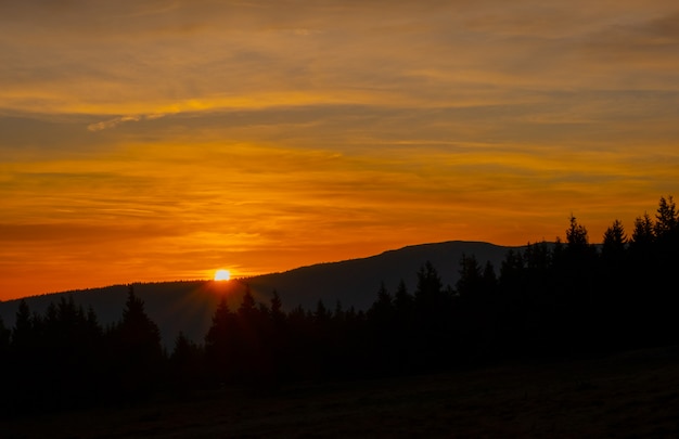 Zonsondergang berg hemel blauw kleurrijke herfst zon licht geel oranje wolken boom rook mist nevel