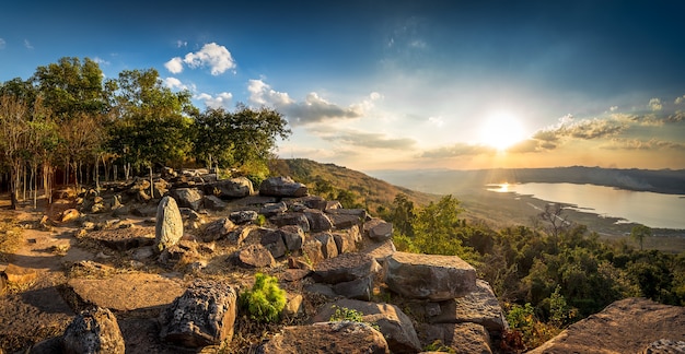 Zonsondergang bij rivier en steenberglandschap