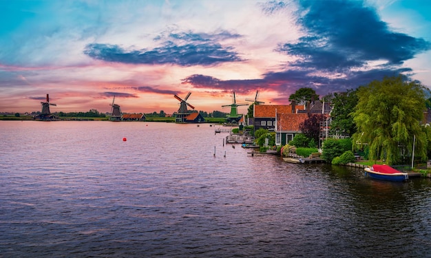 Zonsondergang boven boerderijen en windmolens van de Zaanse Schans in Nederland