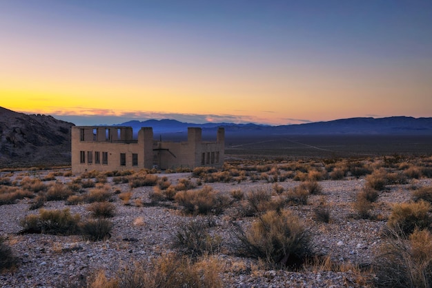 Zonsondergang boven verlaten gebouw in Ryoliet Nevada