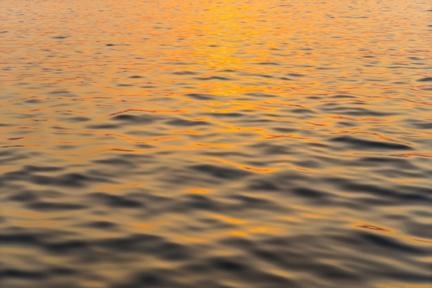 Zonsondergang die de oppervlakte van zeewater overdenkt