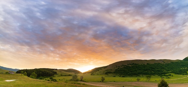 Zonsondergang dramatische hemel boven Montelago hooglanden Marche Italië Zonnestralen tussen wolken boven unieke heuvels en bergen landschap emotioneel gevoel concept