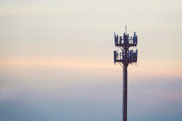 Zonsondergang en lange mast met cellulaire antenne