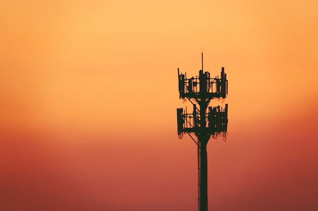 Zonsondergang en lange mast met cellulaire antenne