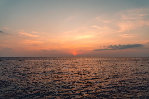 Zonsondergang en wolken boven de oceaan Vrouw die naar de zonsondergang kijkt