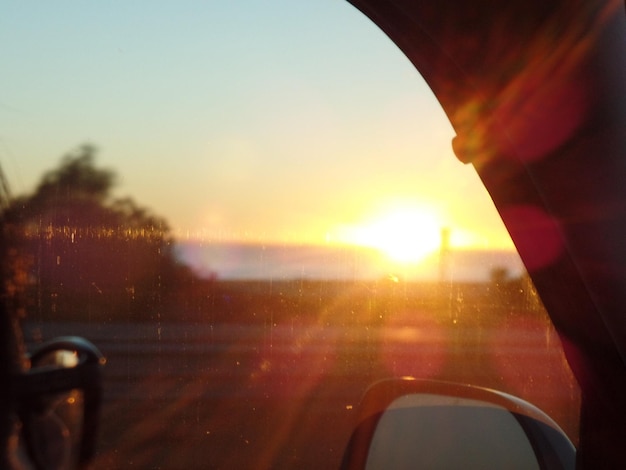 Zonsondergang gezien door de voorruit van een trein