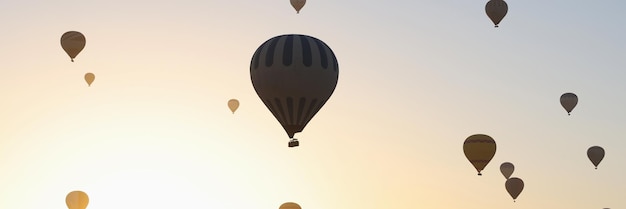 Zonsondergang hemel en vele luchtballonnen over heuvels avonturen en attractie voor toeristen en