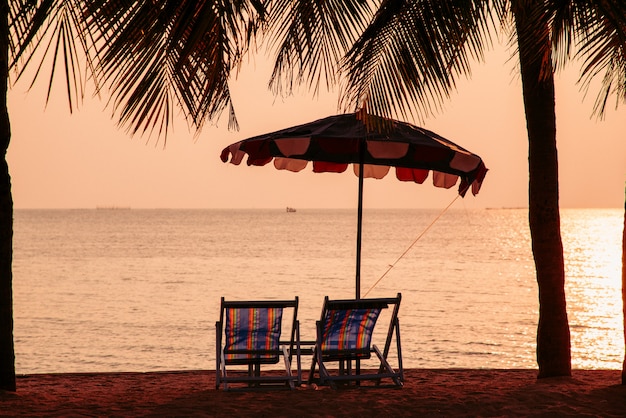 Zonsondergang hemel op het strand met strand paar stoel en kokospalm