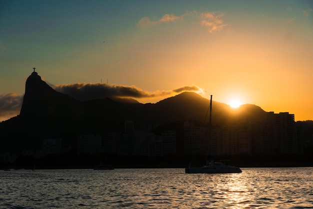 Zonsondergang in de baai van Guanabara inham en stranden van Rio de Janeiro Brazilië met zijn gebouwen boten en landschap Christus de Verlosser bovenop Corcovado Reflectie van de lucht in de zee