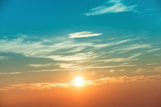 Zonsondergang in de lucht met blauworanje wolken en grote zon