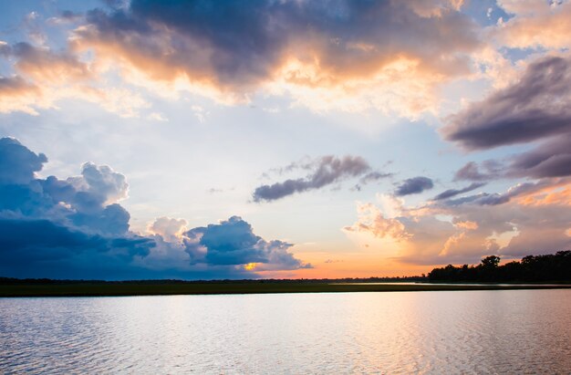 Zonsondergang in het meer. Mooie zonsondergang achter de wolken boven het meerlandschap backg