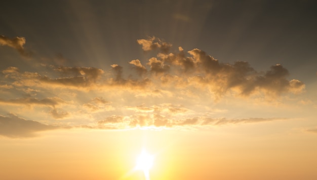 Zonsondergang met zonnestralen, lucht met wolken en zon