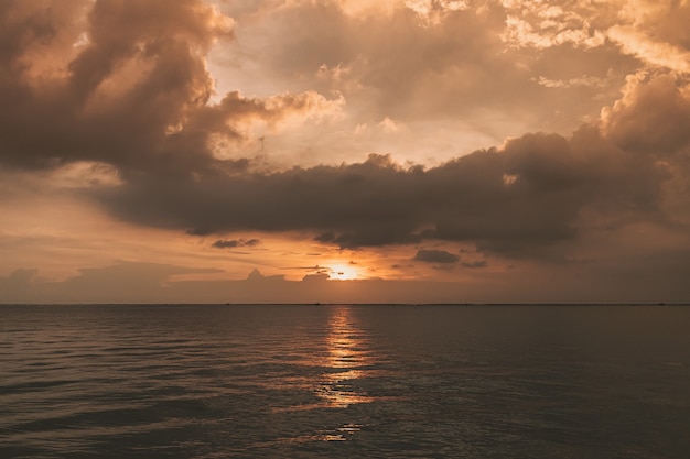 Zonsondergang oceaan met stormachtige wolk in de lucht