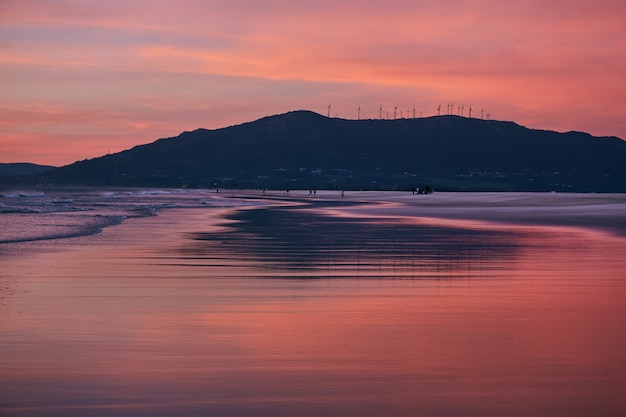 Zonsondergang oceaan strand van Spanje Andalusië. Atlantische Oceaan golven achtergrond heldere magische zomer zonsondergang hemel