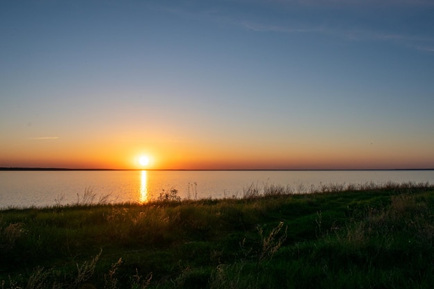 Zonsondergang op de oever van de rivier