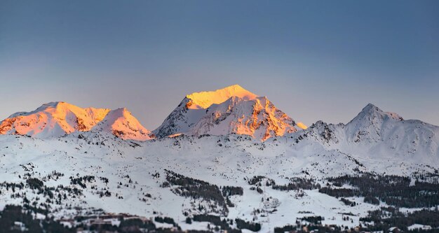 zonsondergang op een besneeuwde bergtop in een alpine skigebied