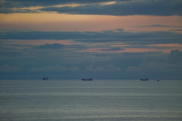 Zonsondergang op zee een paar schepen aan de horizon