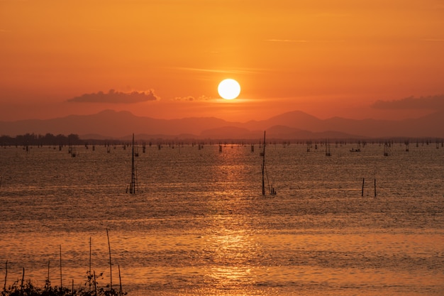 Zonsondergang over bergen van Songkhla-meer met mening van lokale vissende kooien.