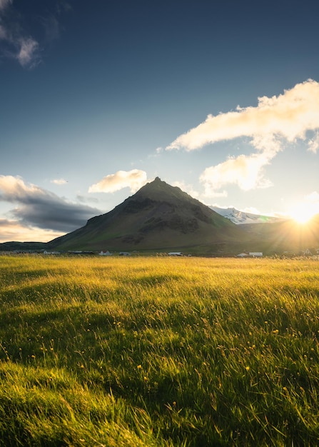 Zonsondergang over de stapafell-berg en gloeiende weide in het dorp arnarstapi in de zomer in ijsland